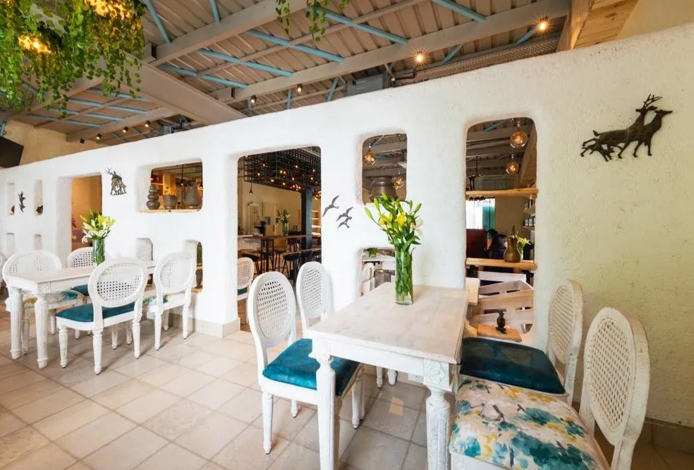 White arches and floral seating at Café Tesu